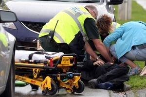 Medics attend to the cyclist who was hit during the pursuit. Photo / Stuart Munro