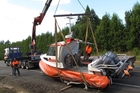 Lifting the Coastguard boat and damaged trailer on to a truck was a tricky operation. Photo / Peter de Graaf Lifting the Coastguard boat and damaged trailer on to a truck was a tricky operation. Photo / Peter de Graaf