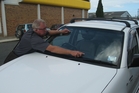 Jim Smith points out the damage to his vehicle's windscreen from loose metal at roadworks south of Whangarei on Friday. Photo / Imran Ali Jim Smith points out the damage to his vehicle's windscreen from loose metal at roadworks south of Whangarei on Friday. Photo / Imran Ali