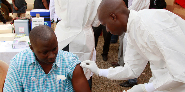A health worker cleans a man's arm before injecting him with an Ebola vaccine. Photo / AP