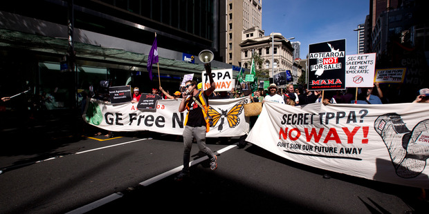 Protesters march down Queen Street in opposition to the government's TPP trade deal talks. Photo / Dean Purcell