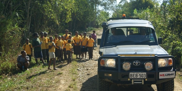 NZDF personnel pass by a group of schoolchildren walking to school in PNG's Western Highlands Province. Photo / Supplied