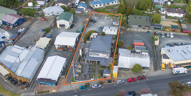 Aerial view depicting the Matakana Village pub and restaurant with property boundaries outlined in orange border and depicting unused land at rear of the property.