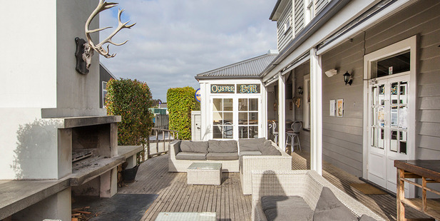 The outdoor seating area with fireplace and entrance to Oyster Bar in the Matakana Village pub and restaurant.