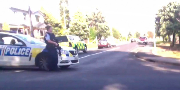 An armed police officer at the scene of the raid. Photo / Supplied