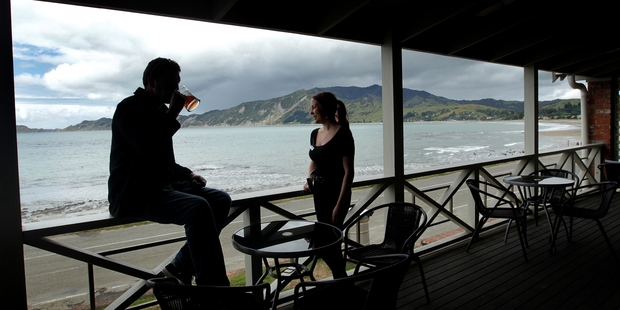 Patrons enjoy the sensational sea views and a couple of quiets on the balcony of the popular Te Puka Tavern in Tokomaru Bay. Photo / Alan Gibson