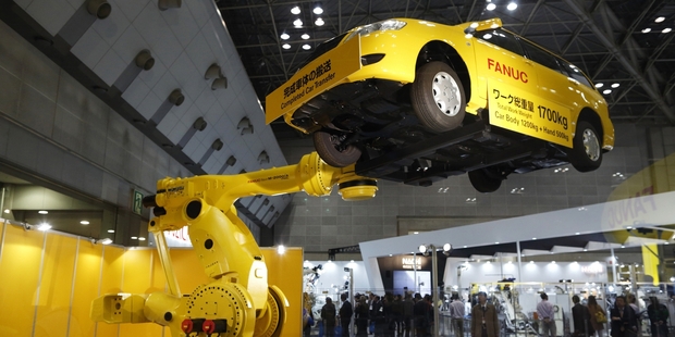 A Fanuc industrial robot moves a car at the International Robot Exhibition in Tokyo. Photo / Washington Post