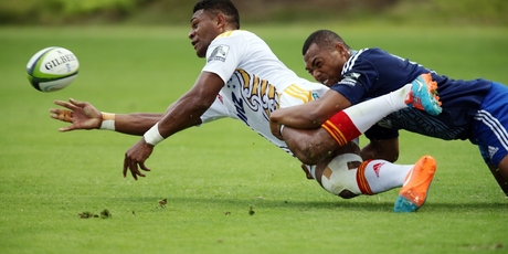 Chiefs centre Seta Tamanivalu offloads in a tackle by Blues winger Tevita Li. Photo / John Stone