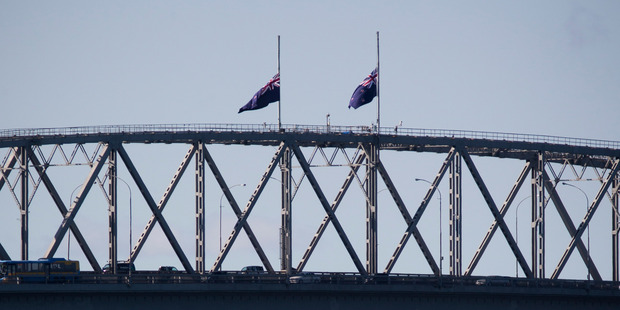 Flags fly at half mast on top of the Auckland Harbour Bridge yesterday to acknowledge the passing of King Abdullah of Saudi Arabia. Photo / Dean Purcell