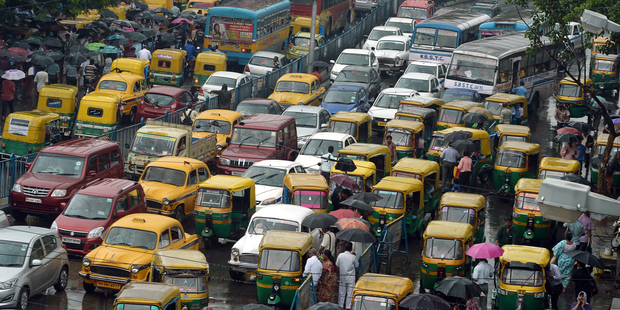 Indian commuters cross the road amid heavy rush hour traffic in Kolkata. Photo / Getty