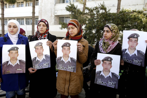 Anwar al-Tarawneh, centre, the wife of Jordanian pilot, Lt. Muath al-Kaseasbeh, who is held by Islamic State group militants, holds a poster of him. Photo / AP