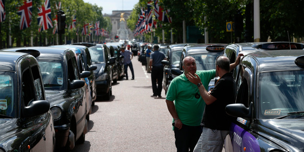 Black cabs and their drivers take over The Mall in front of Buckingham Palace to protest the arrival of app-based ride-hailing schemes like Uber. Photo / AP