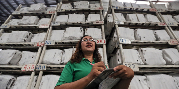 An employee stands in front of bundles of smoked rubber sheets in the warehouse at the Thai Hua Rubber Pcl factory in Samnuktong, Rayong province, Thailand. Photo / Bloomberg