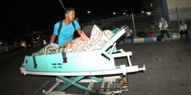 A man pushes a relative who lies on a hospital bed as they were told to leave the building following an earthquake in Padang, West Sumatra, Indonesia.
