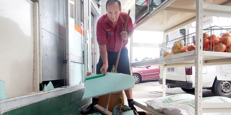 Store owner Gary Henwood cleans up the mess after a burglary. Photo/Andrew Warner