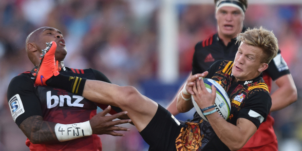 Damian McKenzie of the Chiefs charges over Nemani Nadolo of the Crusaders. Photo / Getty Images