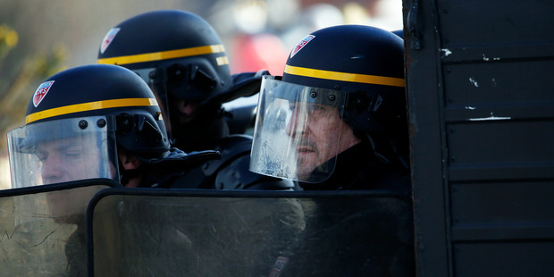 French riot police take position during clashes with migrants. Photo / AP
