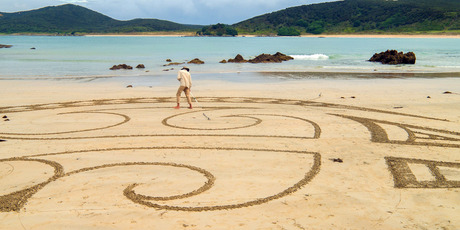 INTER-TIDAL ART: Earthscape artist Andrea Amador at work at Maitai Bay on Monday evening, right.