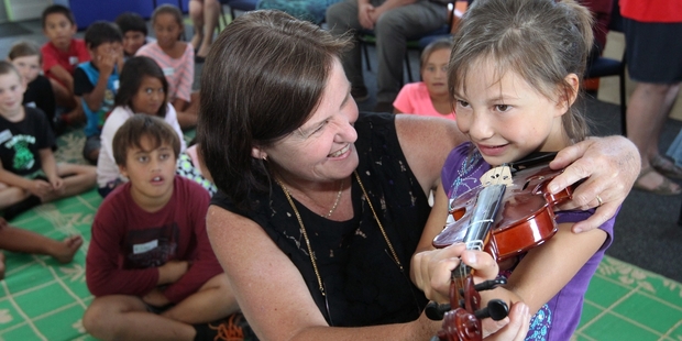 Music tutor Suzie Weeks measures Kimberly Macrae for a small violin. Photo / Duncan Brown