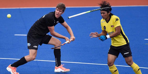 A Malaysian defender loses his stick as Black Sticks striker James Coughlan attacks at Blake Park yesterday. Photo / George Novak
