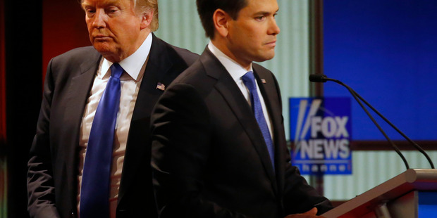 Republican presidential candidate, businessman Donald Trump passes behind Sen. Marco Rubio, R-Fla., during a commercial break at Republican presidential primary debate at Fox Theatre, Thursday, March