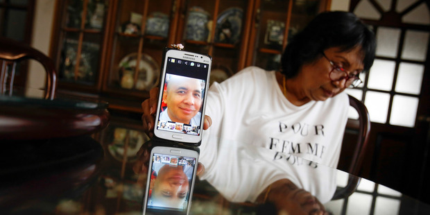 Sakinab Shah, sister of Captain Zaharie Ahmad Shah, holds up her mobile phone with her last photo of her brother. Photo / AP
