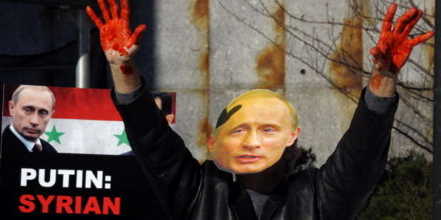 An protester dressed as Vladimir Putin dumps dozens of bloodied body bags outside the UN Security Council building. Photo / Getty Images