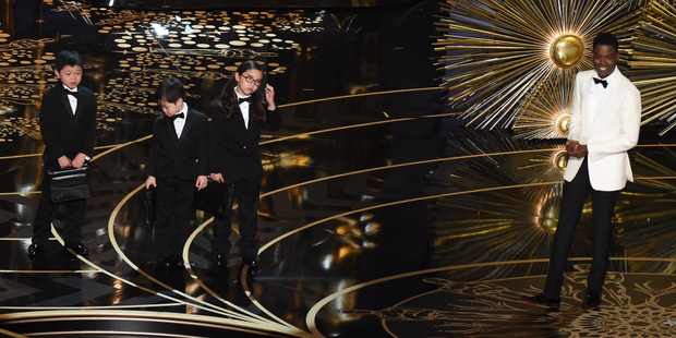 Actor Chris Rock presents Asian children representing accountants from PricewaterhouseCoopers on stage at this year's Oscars. Photo / Getty Images