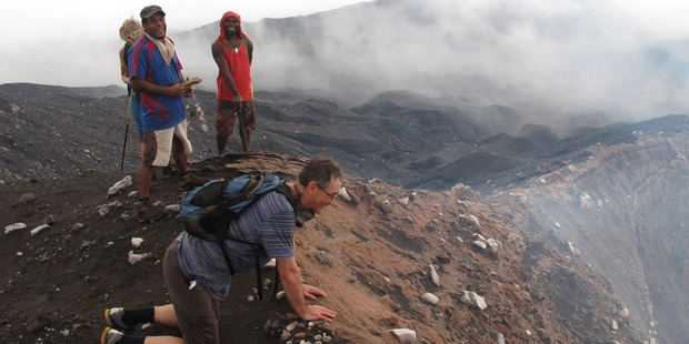 The professor takes a cautious peek over the edge o f Mt Marum's crater. Photo / Peter de Graaf