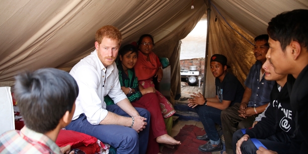 Prince Harry talks to people still living in tents. Photo / AP