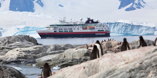 MS Fram navigates near Antartica's Half Moon Island, observed by a colony of Gentoo penguins. Photo / iStock