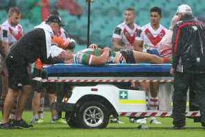Sam Burgess of the Rabbitohs is taken from the field on a media cab . Photo / Getty