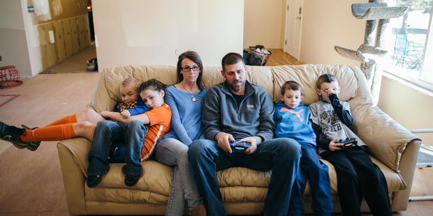 Annette Shattuck and her family sit inside their home in Port Huron, Michigan. Photo by Ali Lapetina for The Washington Post