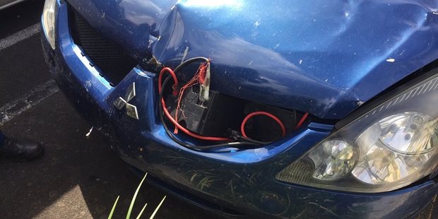 A home-made jump-starter kit was stuck on the Mitsubishi's dented and slightly detached bonnet. Photo / Facebook/Cambridge Police