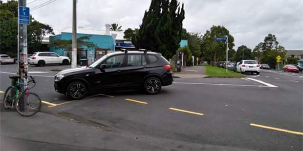 The picture, which has been shared on Facebook, shows the car parked on a diagonal in the middle of the road, with its front end just over the edge of the bus-stop. Photo / Facebook