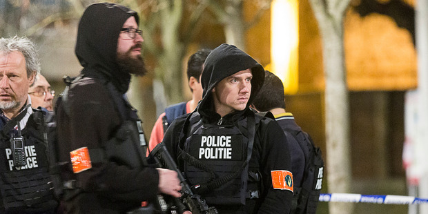 Police officers secure an area during an apartment raid in Brussels. Photo / AP