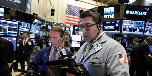Traders Robert Charmack, left, and Michael Capolino work on the floor of the New York Stock Exchange. File photo / AP