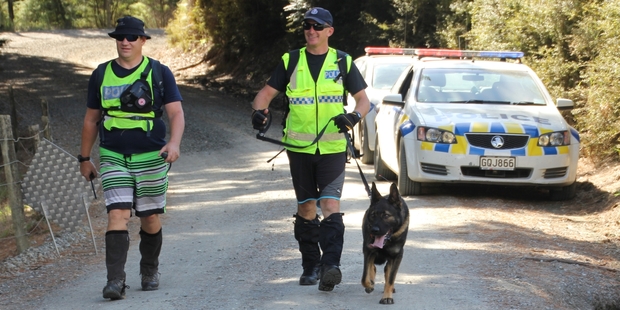 Sergeant Craig Burrows of Kamo police and Constable Tony Harris of Auckland emerge after searching the bush with Phoenix, a police dog trained to locate bodies. Photo / Peter de Graaf