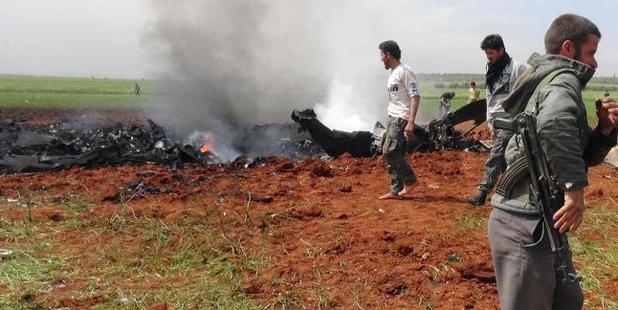 Syrians check the wreckage of a government warplane after Al-Nusra front (Al-Qaeda's Syria affiliate) reportedly shot it down and captured one crew member alive. Photo / AFP