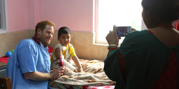 Prince Harry, left, poses for a photo with a young patient during a recent visit to the burn victim ward in Kanti Children Hospital in Kathmandu, Nepal. Photo / AP