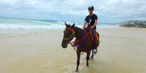 Andrew rides a horse along Queensland's Rainbow Beach. Photo / Andrew Louis
