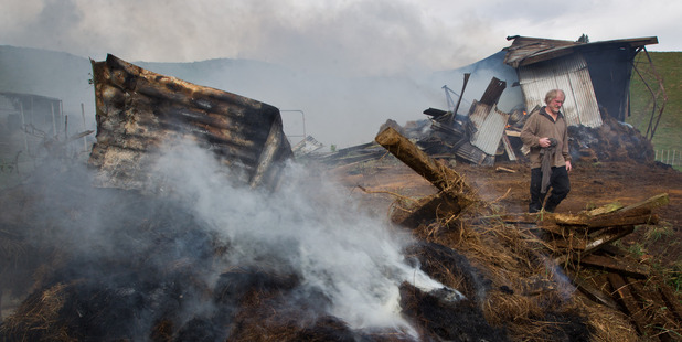 Dennis Russell inspects the area where his hay barn was struck by lightning. PHOTO/STEPHEN PARKER