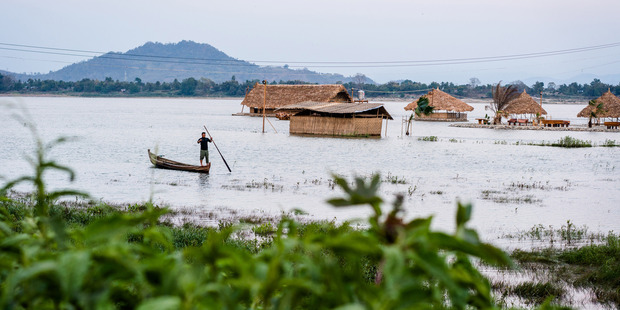 A man fishes from a small boat near a floating restaurant on the Irrawaddy River. Photo / Washington Post