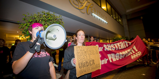 Police officers stood at the door of Auckland's Heritage Hotel tonight, as about 80 protesters played music and chanted outside the venue. Photo / Chris loufte