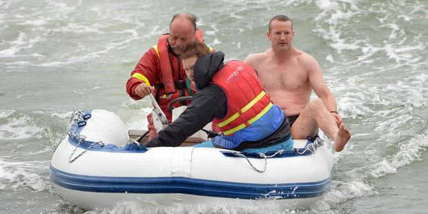 Rescuers (from left) Neil George, Maximilian Bauer and Constable Rhys Davidson return to shore during the water rescue. Photo: Stephen Jaquery
