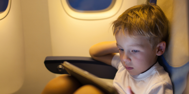 More parents are reaching for tablets to keep kids occupied on long flights. Photo / iStock