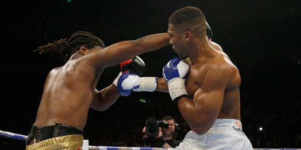 US boxer Charles Martin, left, is knocked down by British boxer Anthony Joshua during their IBF heavyweight title bout at the O2 Arena in London. Photo / AP.