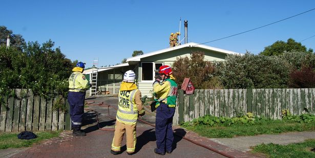 Firefighters extinguishing a house fire in Featherston yesterday. PHOTO/ALISA YONG