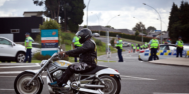 A motorcyclist riding through heavy police presence at Te Paeroa Rd Roundabout in Bethlehem. Photo/Andrew Warner