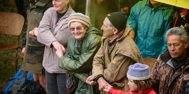 SINGING IN THE RAIN: Anzac Day service goers in 2013 join hands to sing Auld Lang Syne at the trig site. PHOTO/FILE
